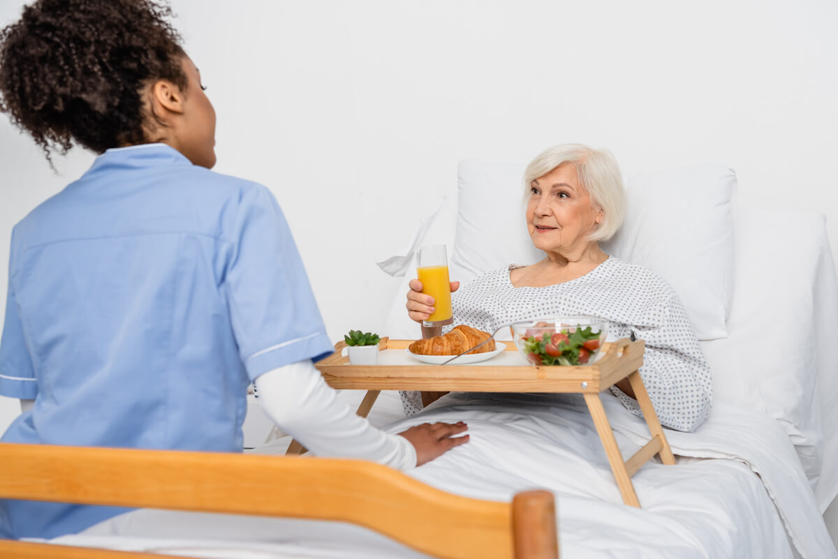 senior-patient-looking-at-african-american-nurse-n-ZEK3HMG.jpg